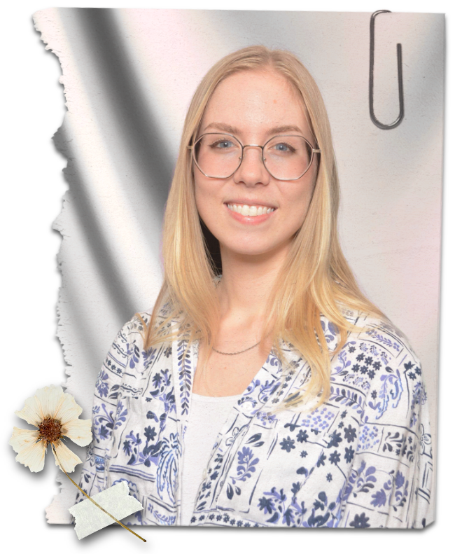 A professional headshot of the author. She is a smiling young woman with blonde hair, fair skin, and blue eyes. She is wearing a blue and white aloha shirt and is standing in front of a white fabric background.